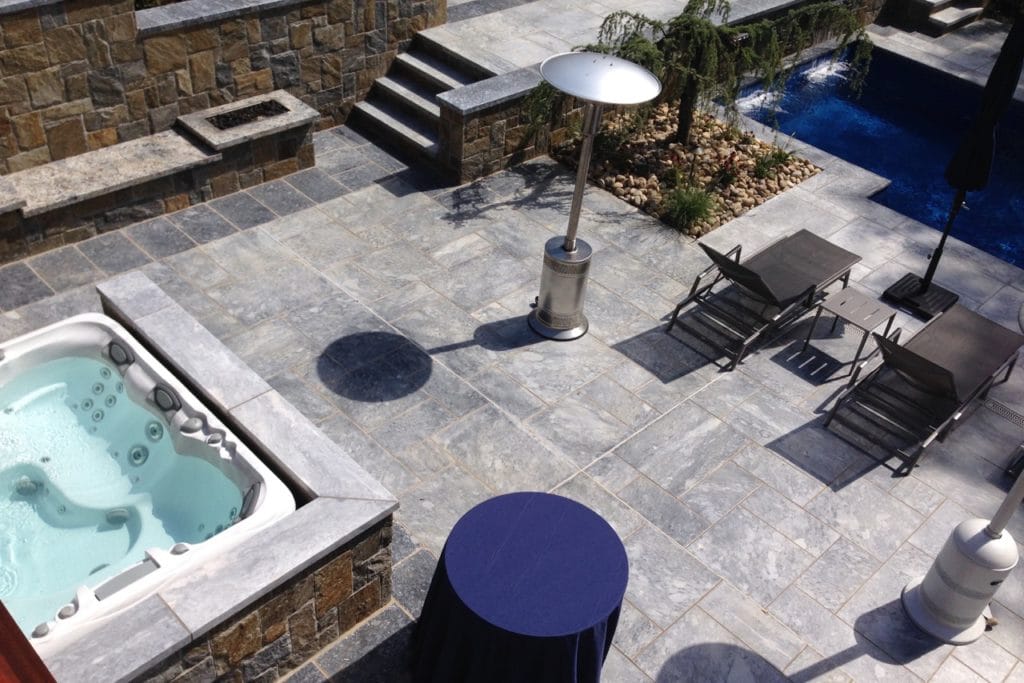 Terrazza con piscina e idromassaggio in lastre di pietra grigia