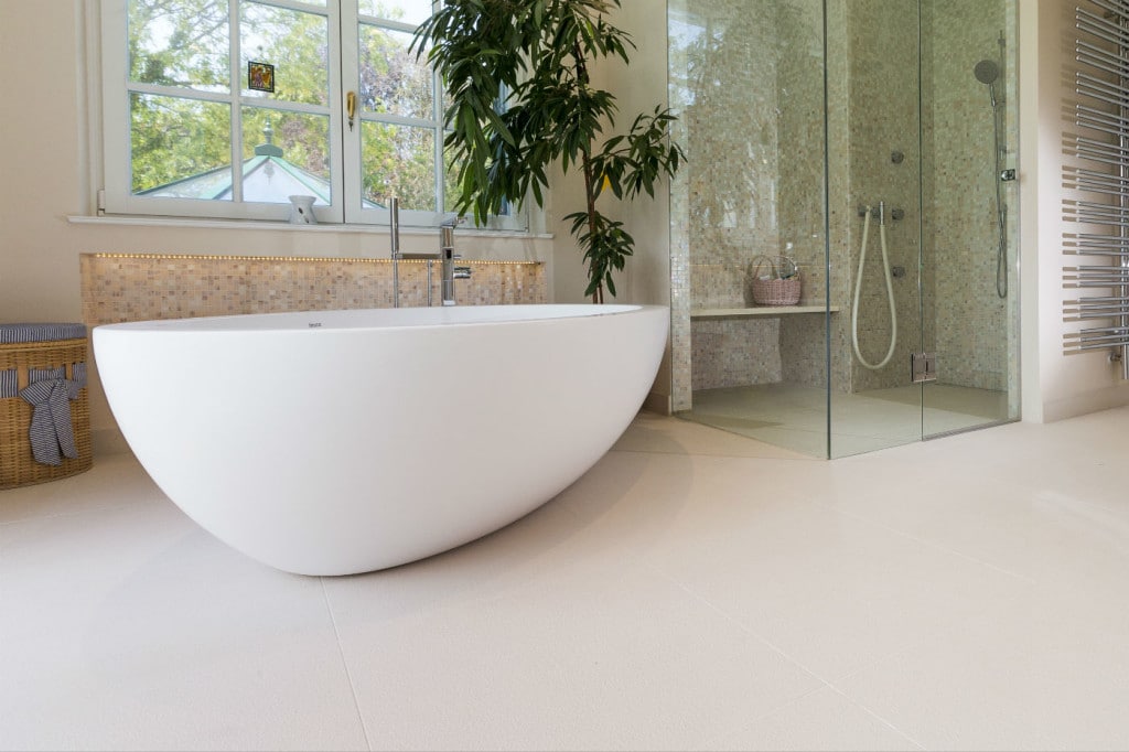 Luxury bathroom with porcelain stoneware floor tiles in beige in a wall covering of glass mosaic