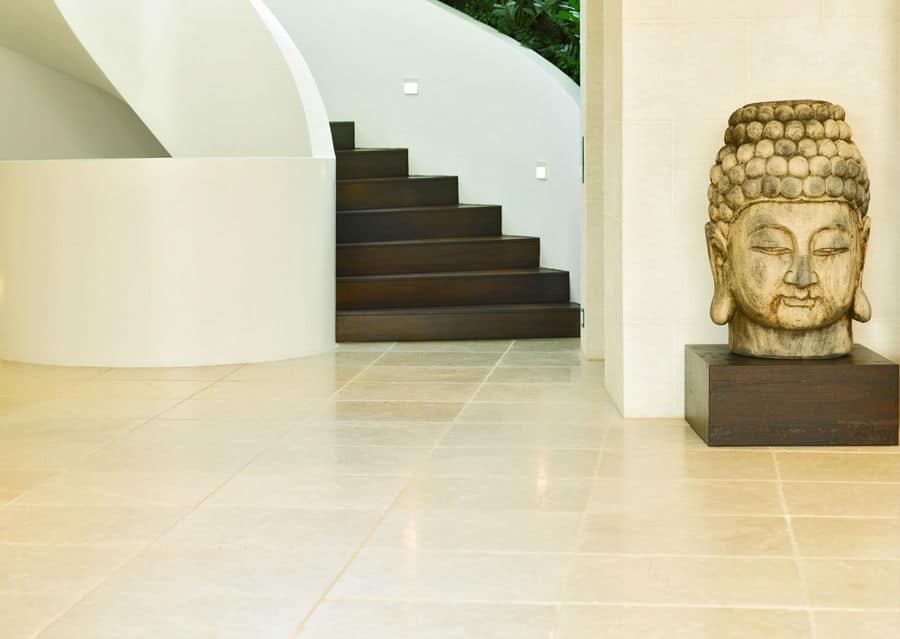 Suelo de piedra natural en el interior de la caliza Levante Crema en el pasillo con un gran Buda