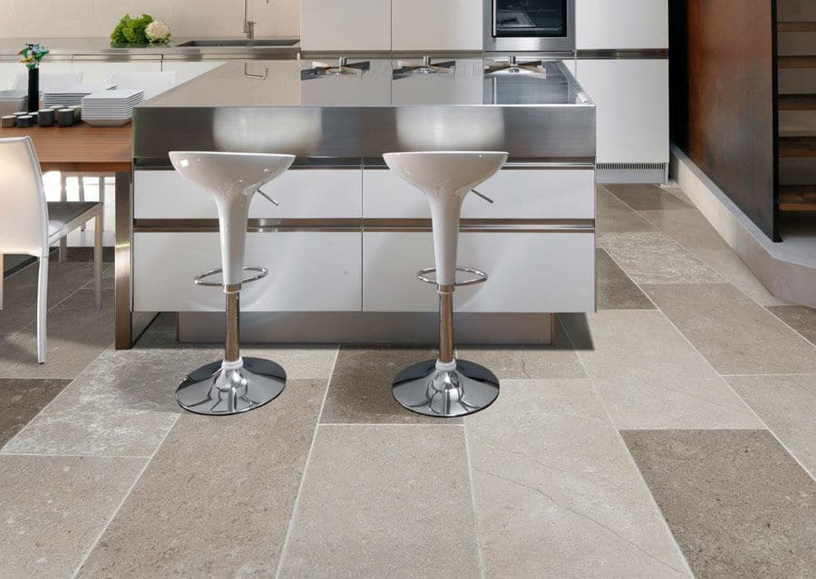 Pavimento in pietra naturale con grandi piastrelle di diversi colori in tono marrone in una cucina moderna