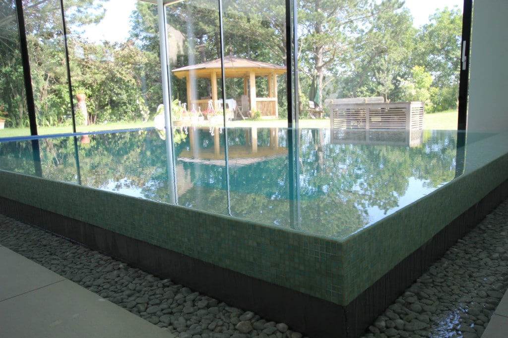 Pavimento in tecno pietra, piscina interna in mosaico di vetro